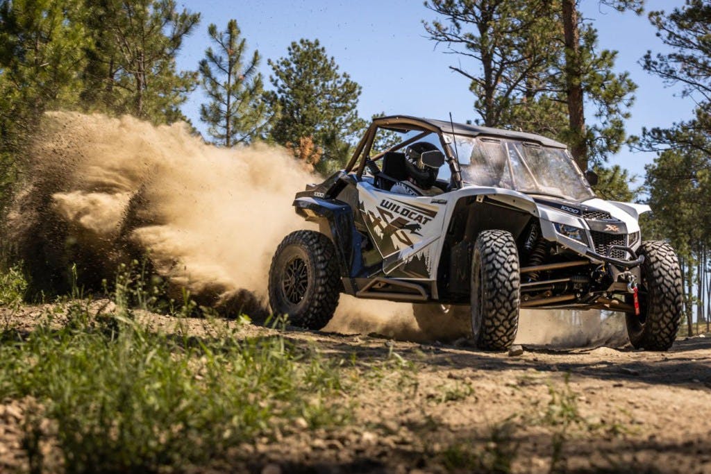 2025 arctic cat wildcat xx drifting around a dirt corner.