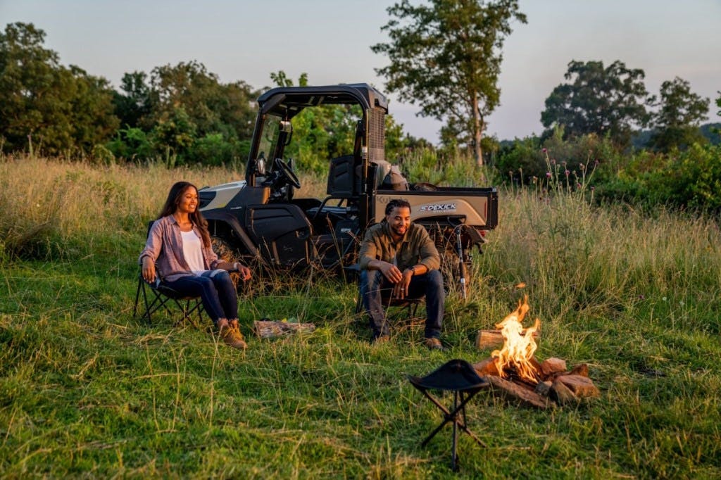 2025 Kubota Sidekick beside a camp fire.