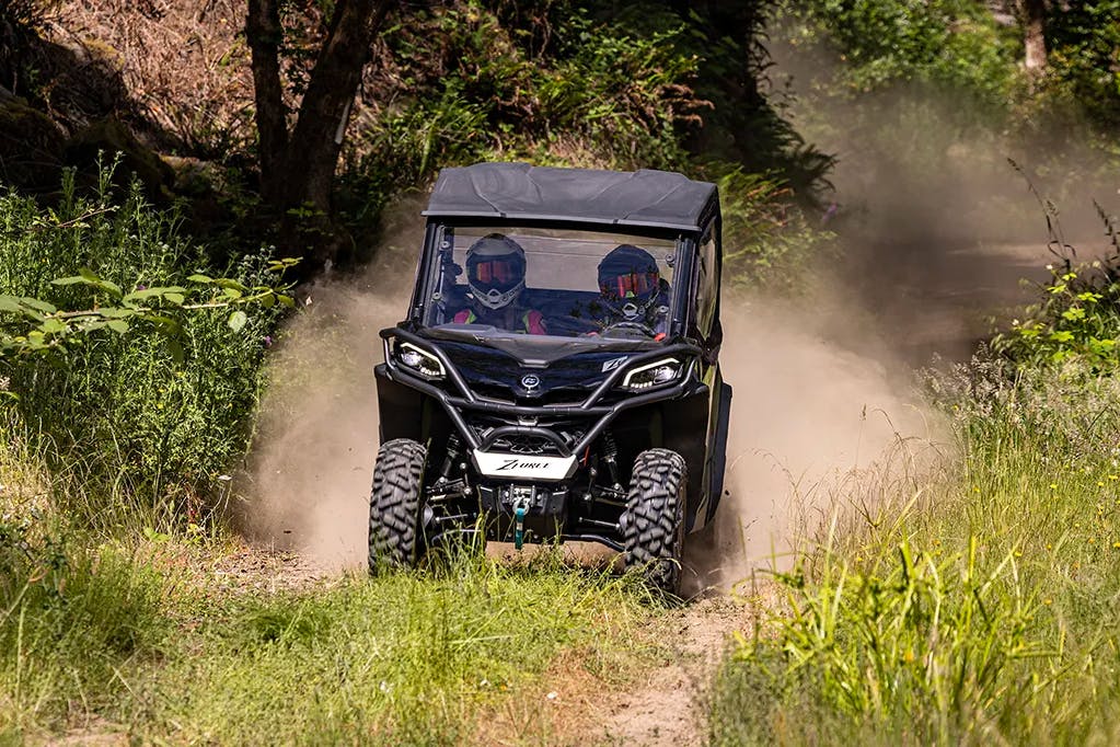 2025 CFMoto ZForce 800 Trail driving on a dusty trail.