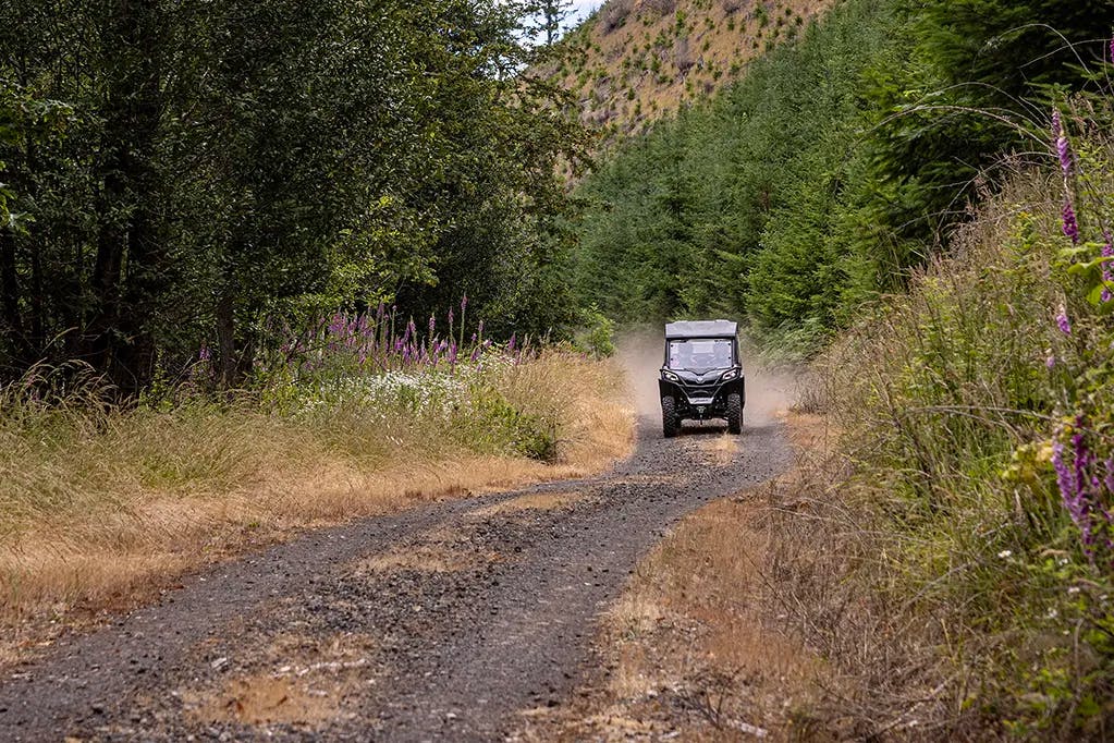 2025 CFMoto ZForce 800 Trail driving down a gravel road.