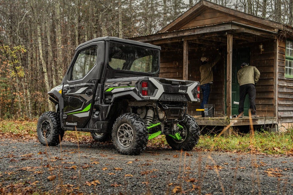 2025 Kawasaki Ridge XR parked outside a large outhouse, but it's locked.