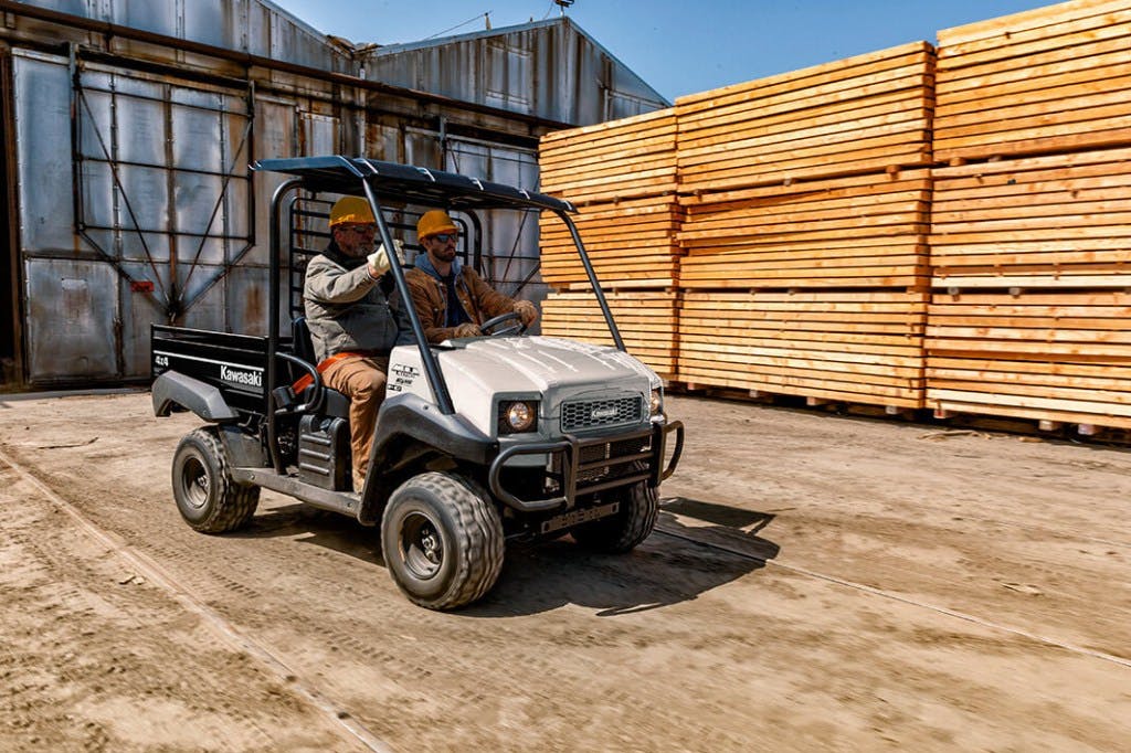 2024 Kawasaki Mule 4010 hiding from the foreman behind three large piles of construction grade timber.
