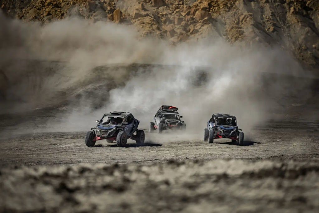 Three Can-Am Maverick R Max side by sides in the desert.