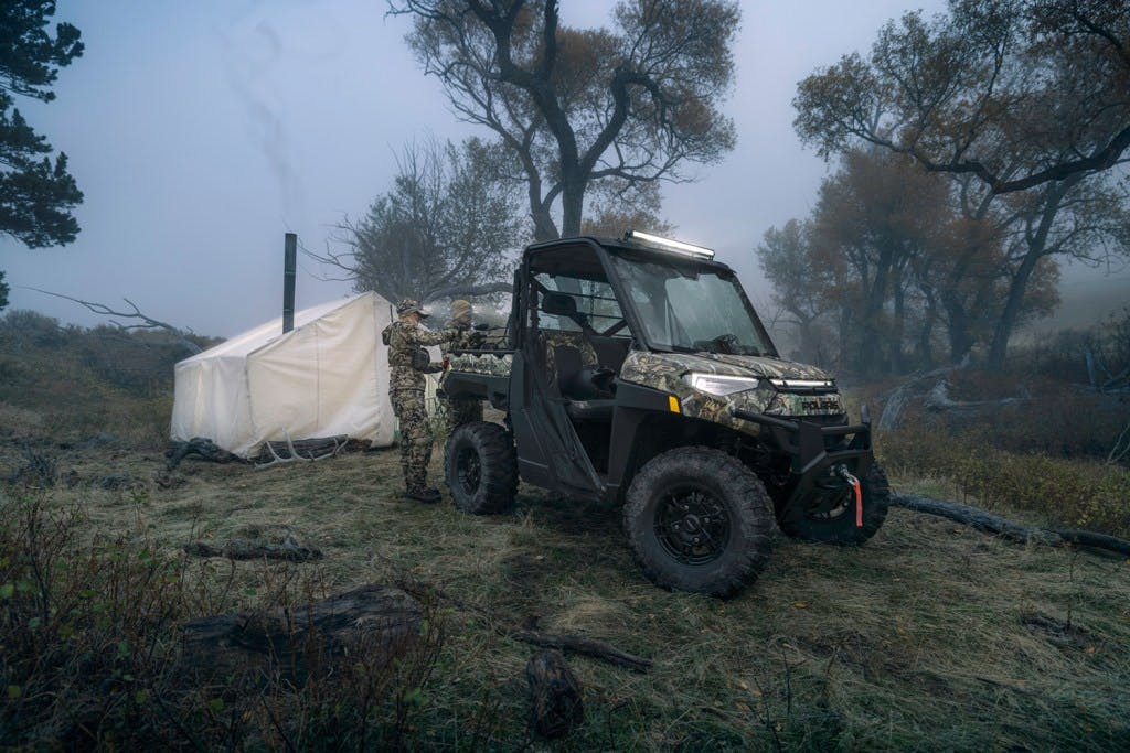 2024 Polaris Ranger Kinetic EV in a foggy field with a tent