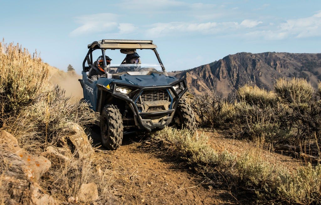 2025 Polaris RZR Trail Sport on a grassy trail in the mountains
