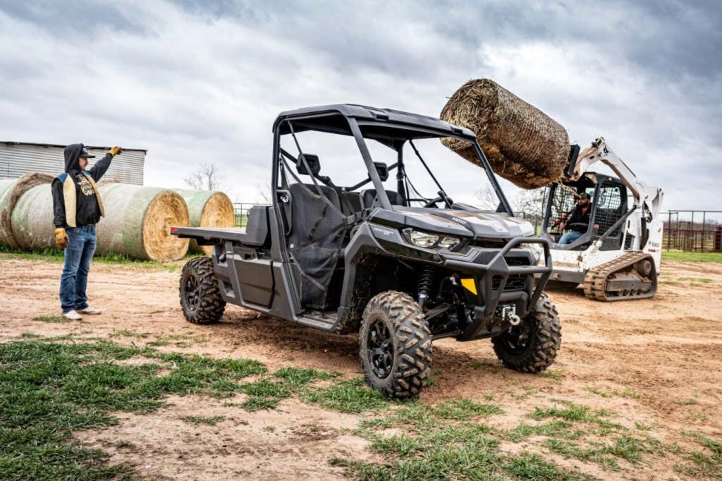 2025 can-am defender pro being loaded by a skid-steer