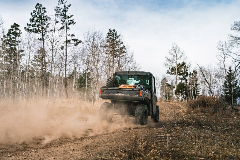 2025 Polaris Ranger XP 1000 Northstar Premium dirt road trees blue sky