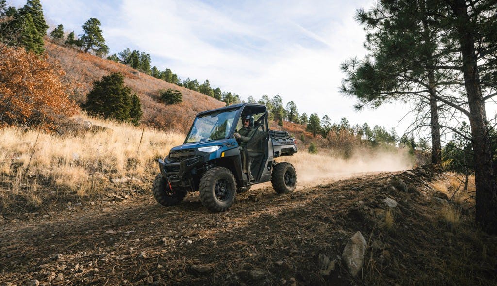 2025 Polaris Ranger XP 1000 Northstar dirt road trees blue sky
