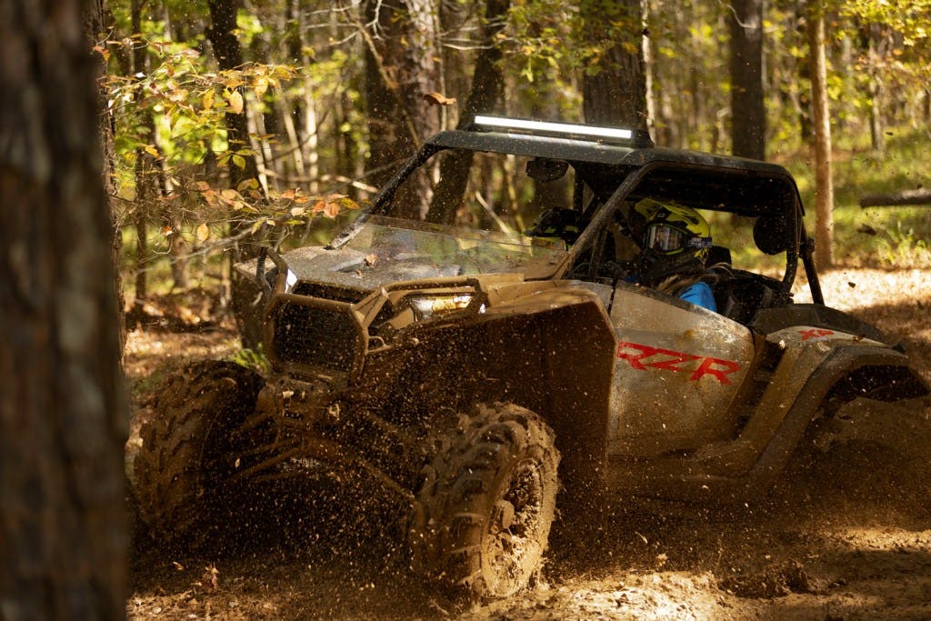 2025 Polaris RZR XP Premium between trees covered in mud