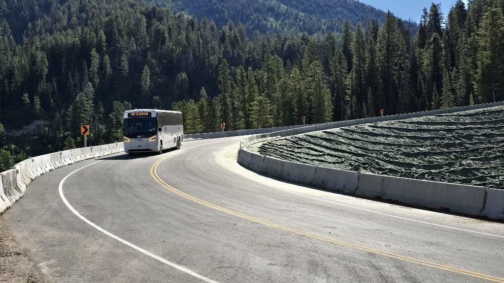 Teton Pass Highway 22 is open again after 3 weeks of closure.  Image of bus driving on detour. 