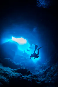 scuba diver deep in underwater hole