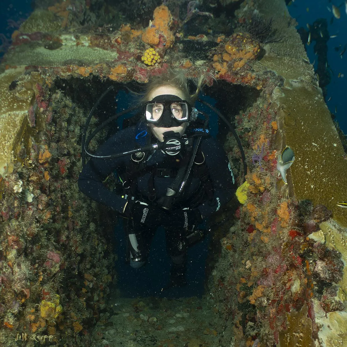 Scuba diver swimming through underwater structure
