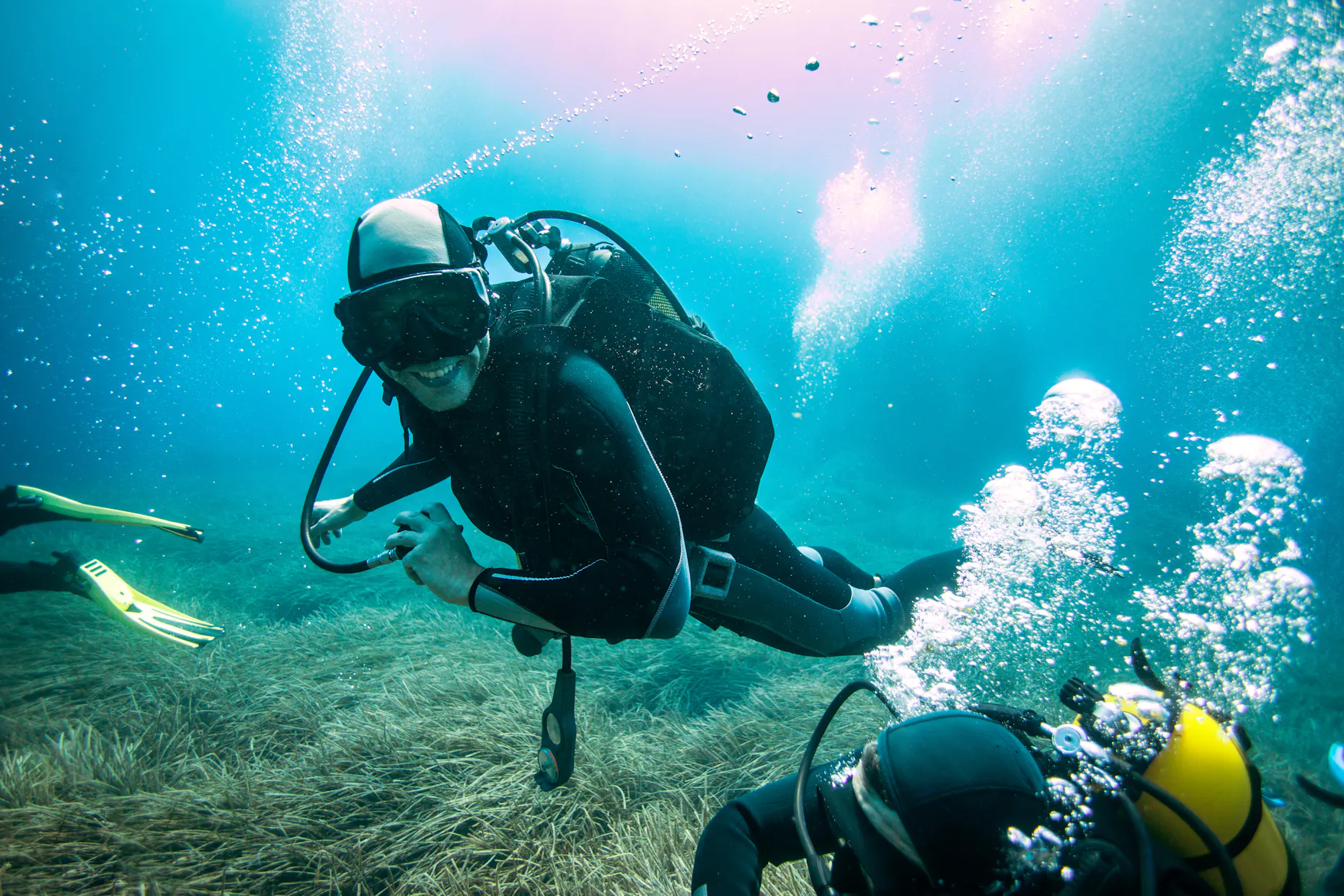 Scuba diver scuba diving underwater without regulator in mouth.