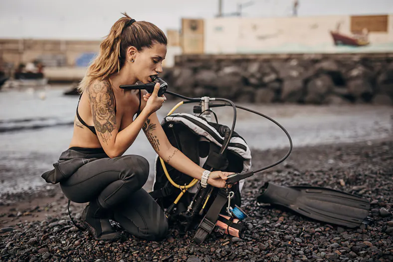 female diver examining scuba gear