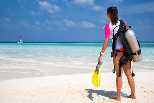 Diver standing on beach with scuba gear