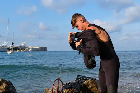 Young spearfisherman donning his wetsuit