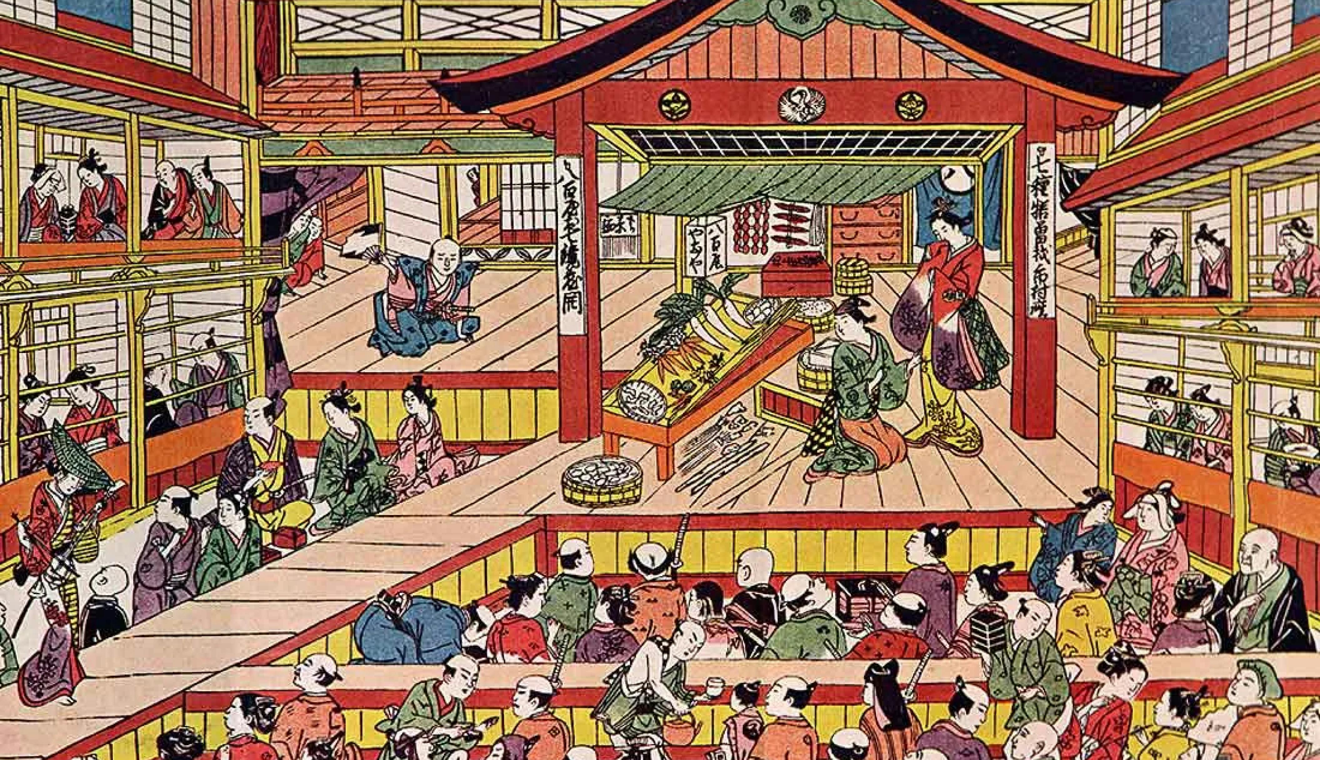 A colorful woodblock print depicting a bustling scene in a multi-story Japanese building, likely a theater or entertainment venue. Numerous figures in traditional Japanese attire are engaged in various activities, including watching a performance, eating, and conversing. The architecture is detailed, showcasing wooden beams, balconies, and a stage-like area.