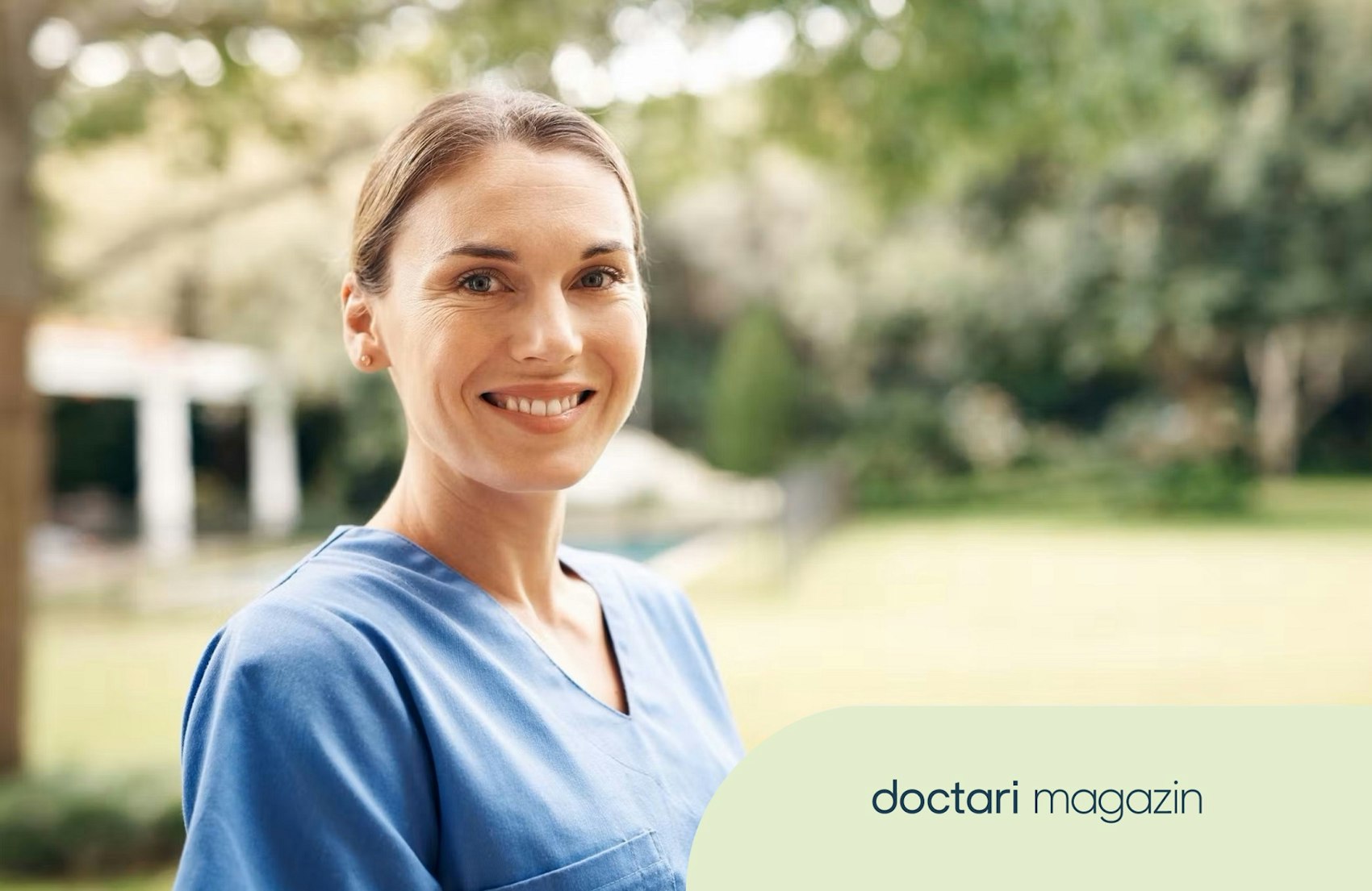 Junge Pflegerin im Kasack lächelt in die Kamera