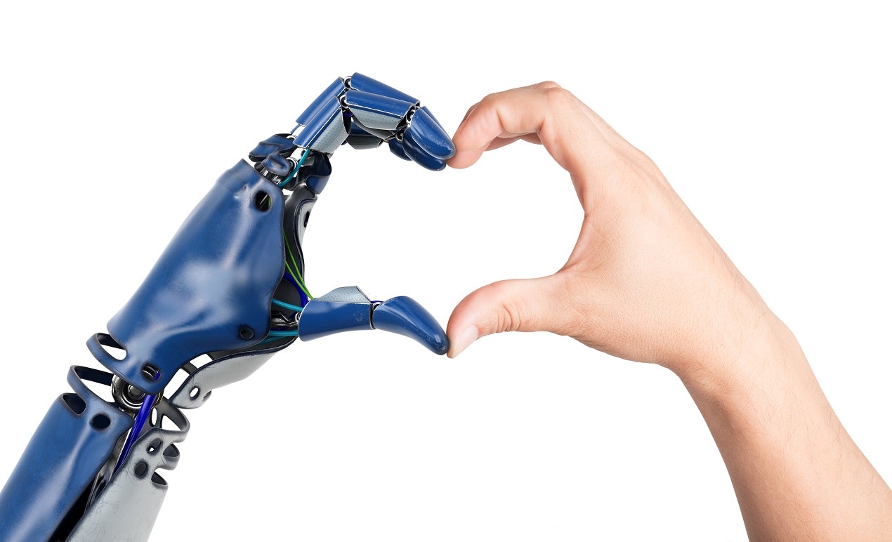 Die Hand eines Roboters und eine menschliche Hand formen zusammen ein Herz