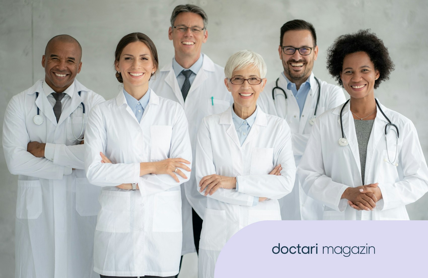 Mehrere Ärztinnen und Ärzte in weißen Kitteln lächeln in die Kamera