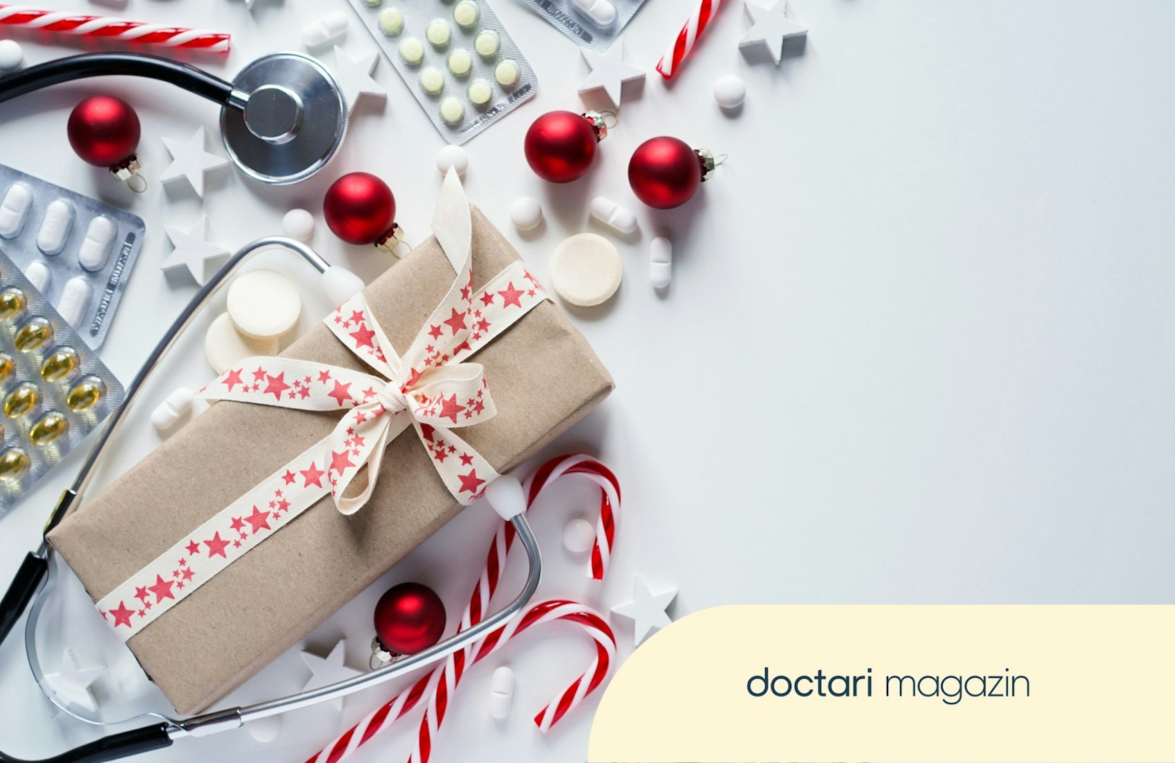 Ein Weihnachtgeschenk liegt auf einem Tisch neben Tabletten und einem Stethoskop.