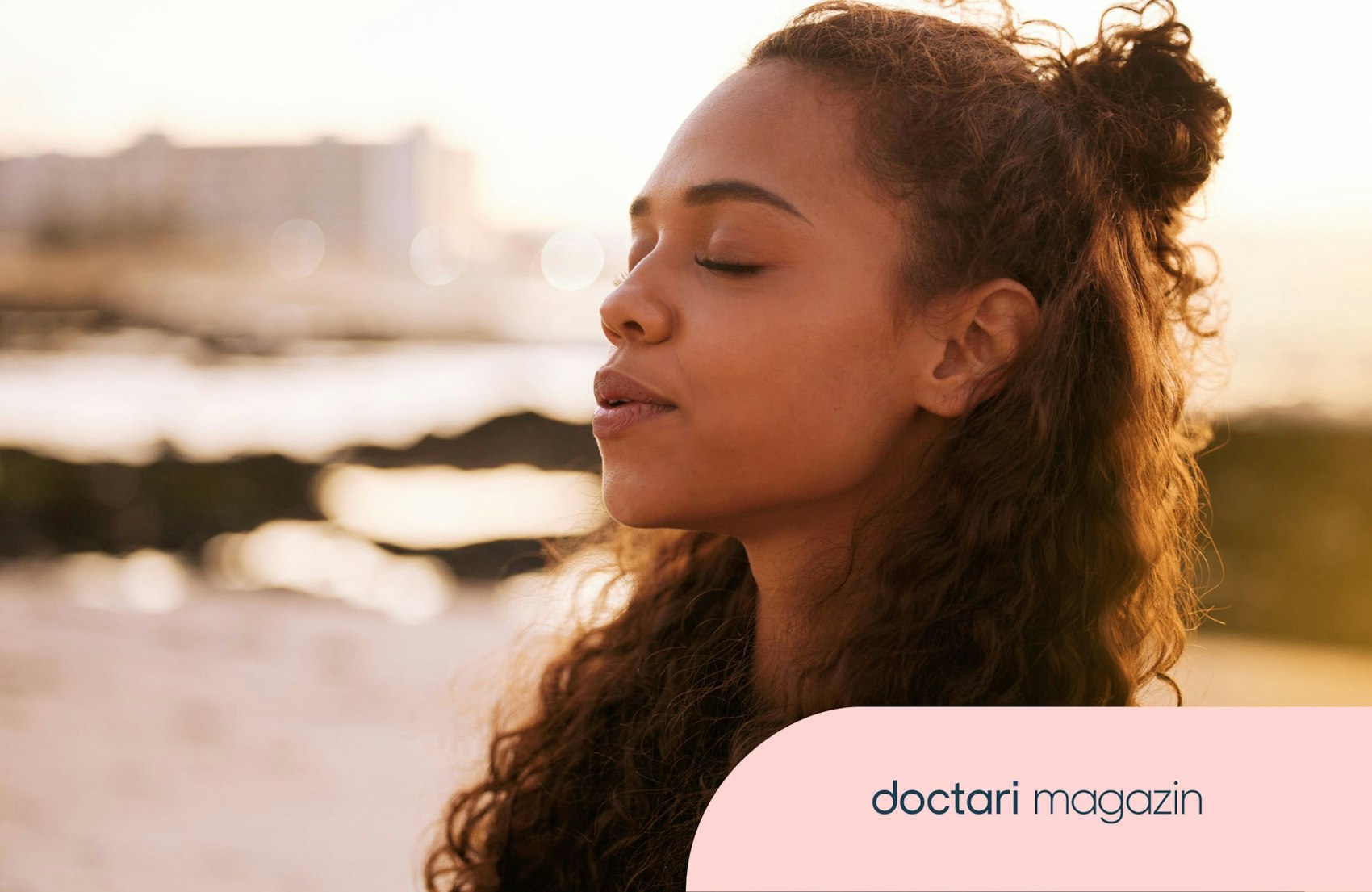 Junge Frau steht mit geschlossenen Augen mitten in der Natur und meditiert.