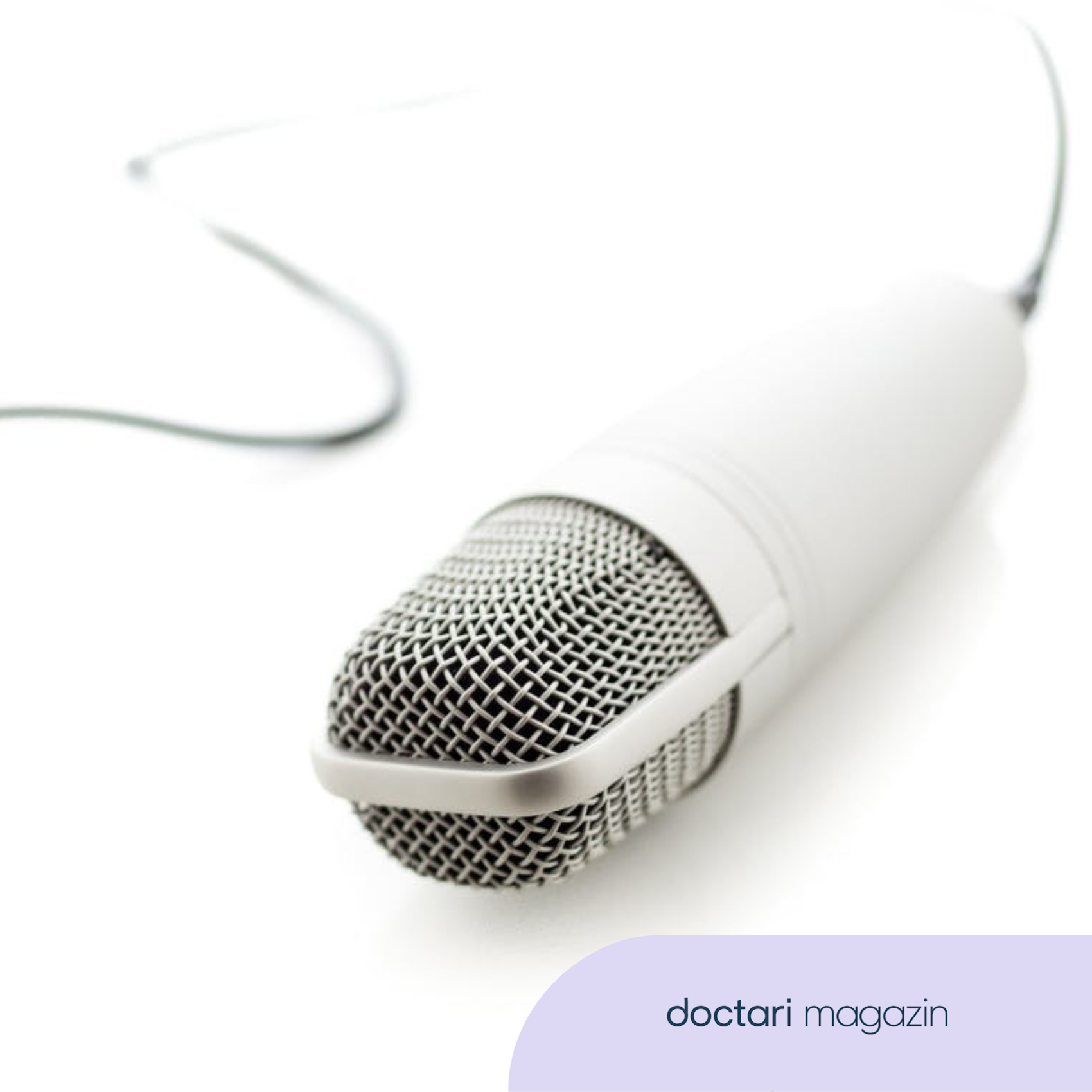 Ein weißes Mikrofon liegt auf einem weißen Tisch.