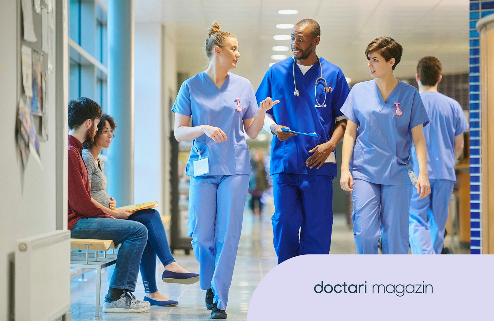 Drei Pflegefachkräfte laufen einen Krankenhausflur entlang.