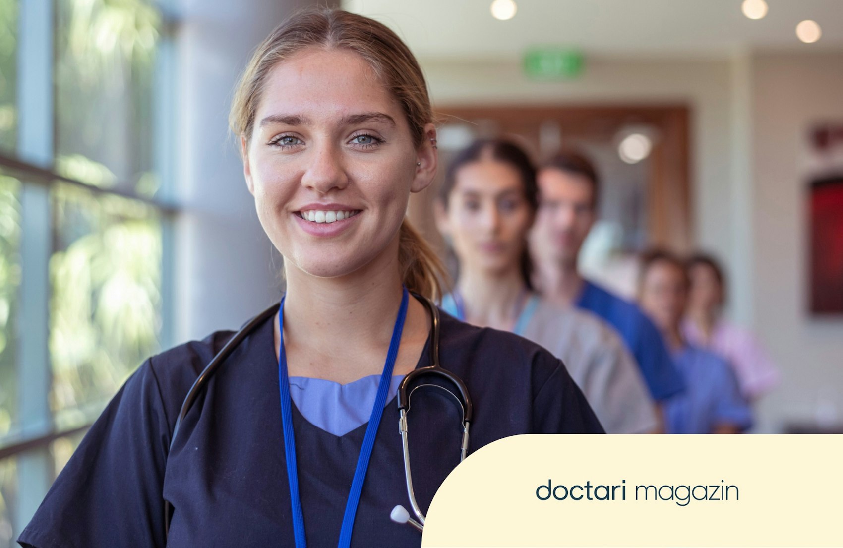 Junge Ärztin lächelt in die Kamera, hinter hier stehen noch vier weitere Beschäftigte einer Klinik