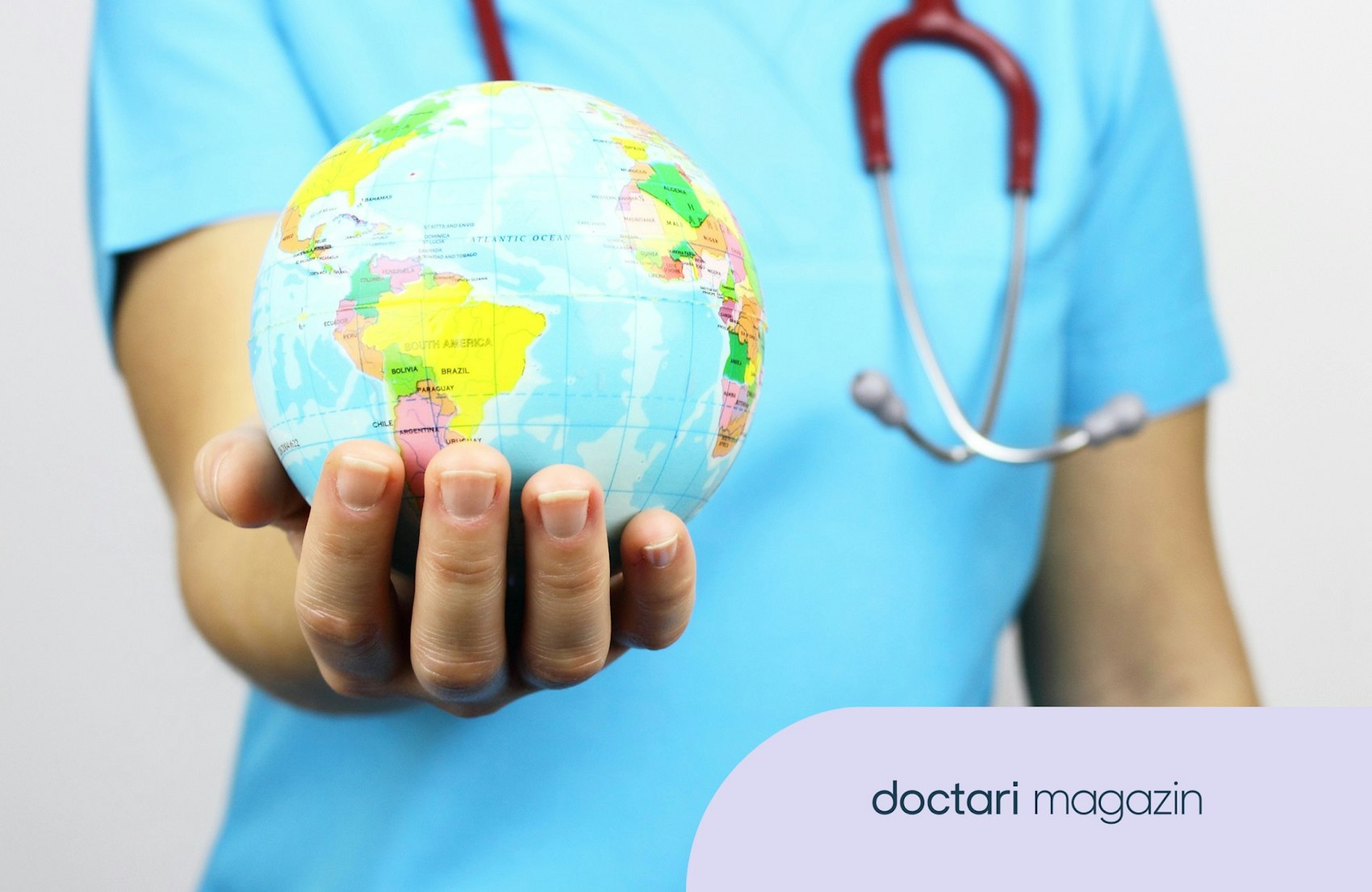Eine medizinische Fachkraft hält einen kleinen Globus in der Hand.