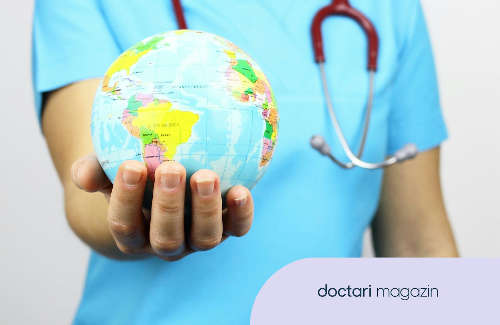 Eine medizinische Fachkraft hält einen kleinen Globus in der Hand.