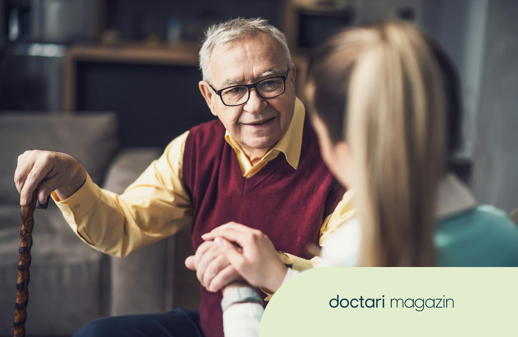 Eine Pflegekraft hält die Hand eines älteren Patienten.