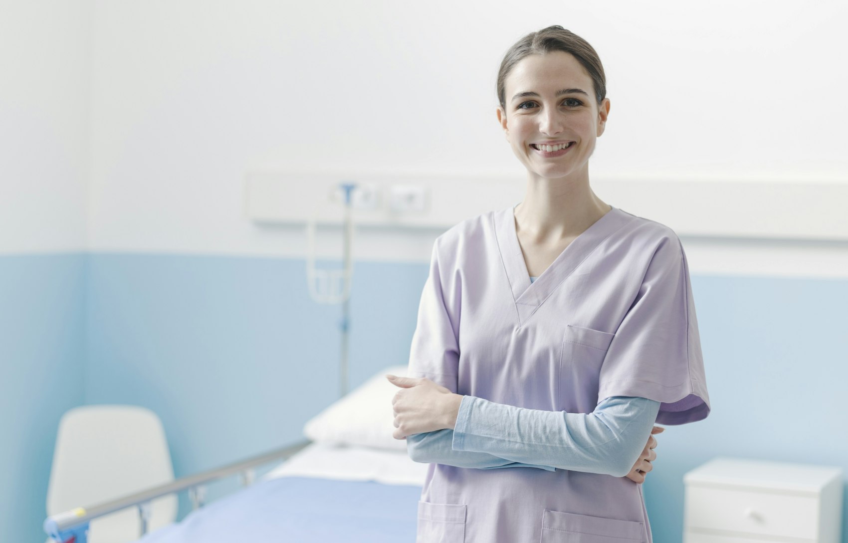 Lächelnde junge Krankenschwester in einem Patientenzimmer
