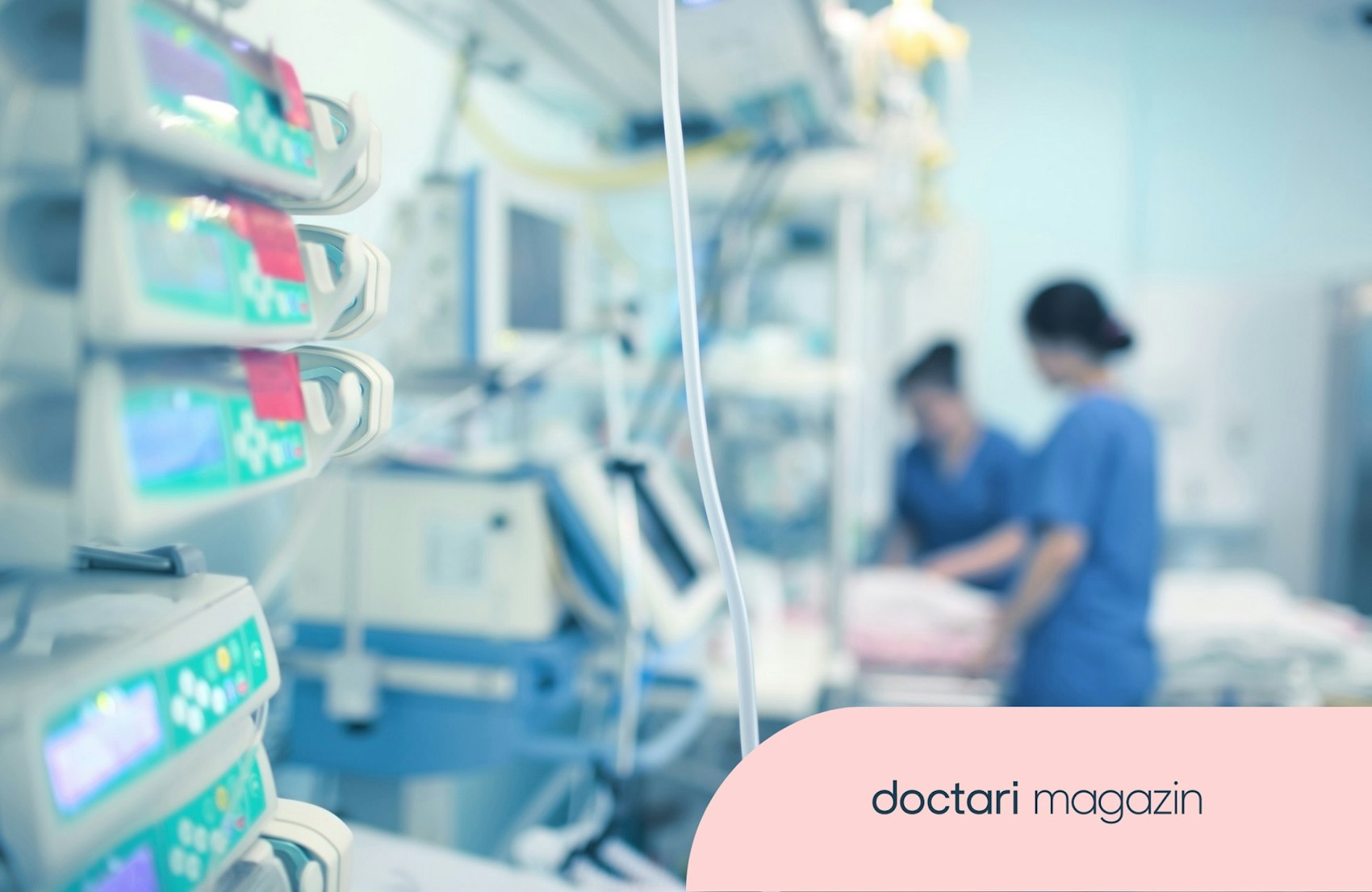 Blick in eine Intensivstation. Im Hintergrund sind verschwommen zwei Intensivflegerinnen am Krankenbett zu sehen