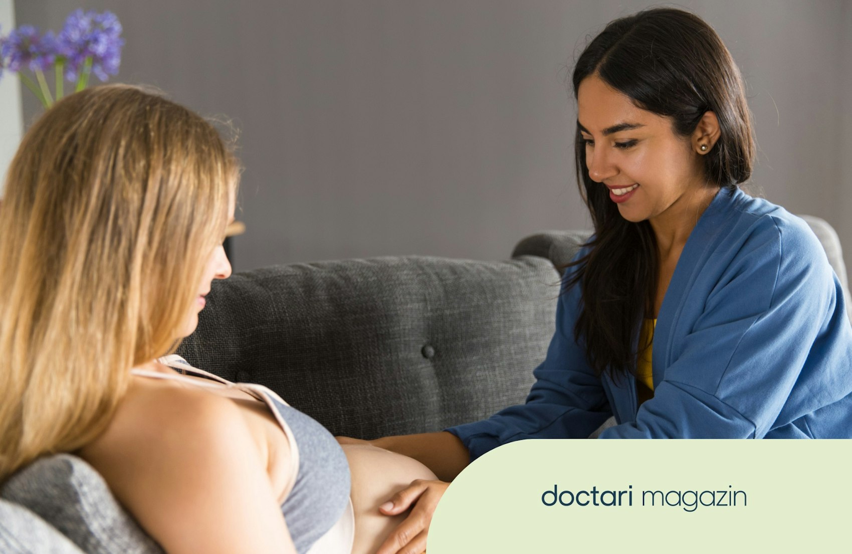 Eine junge Hebamme untersucht den Bauch einer schwangeren Frau.