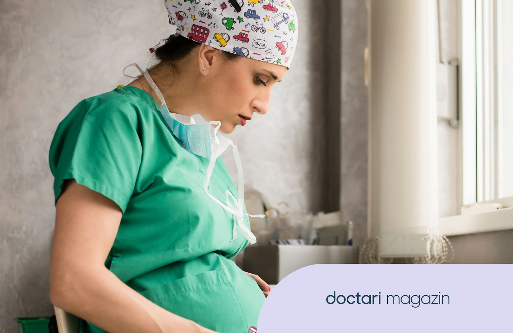 Eine schwangere Chirurgin in grüner OP-Kleidung sitzt auf einem Stuhl und liest.