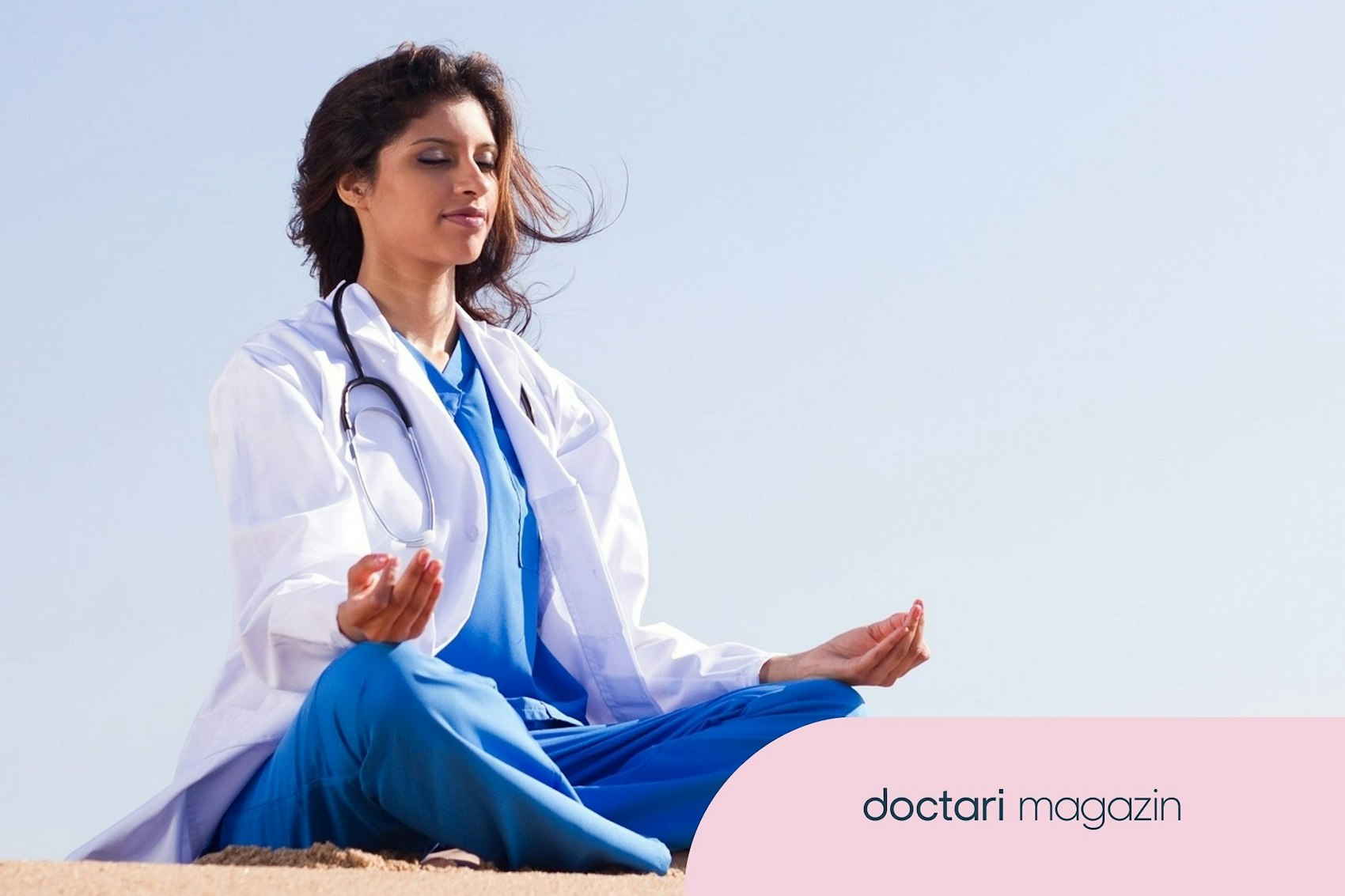 Eine junge Ärztin sitzt im Schneidersitz mit den Händen in einer meditativen Haltung unter freiem Himmel.