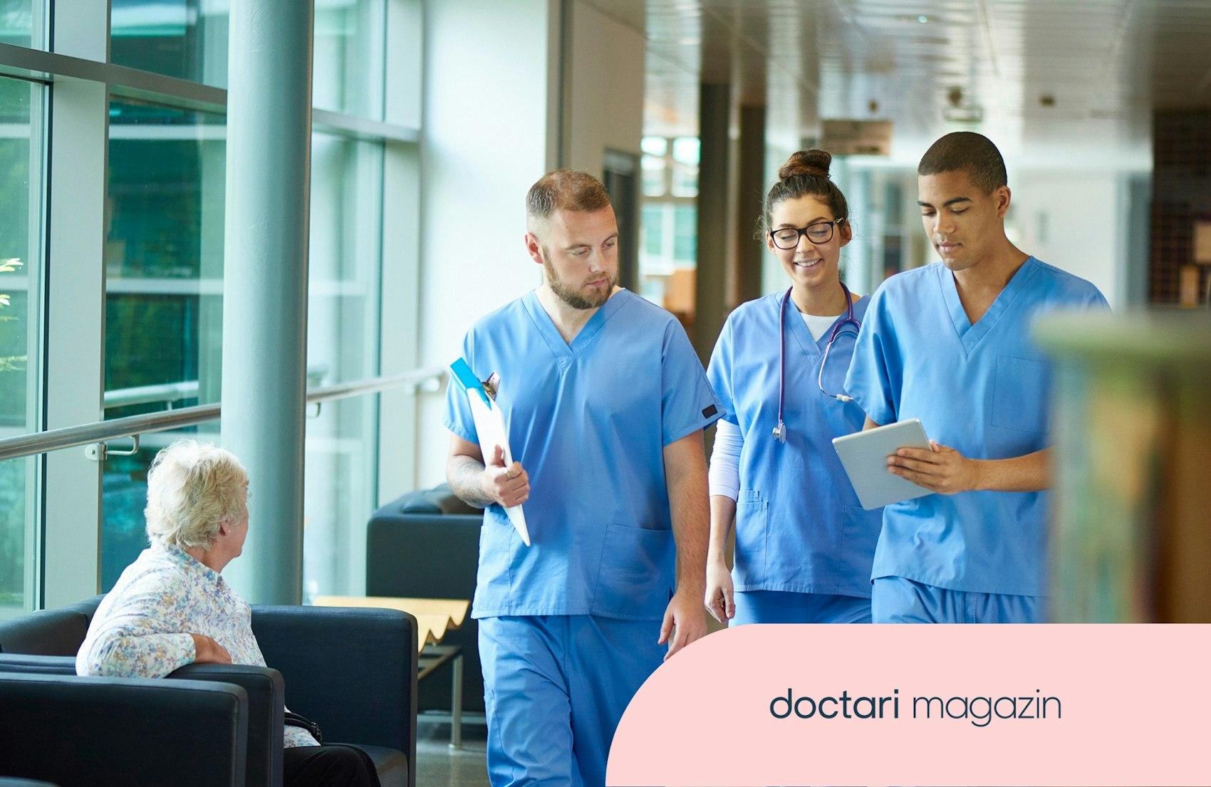 Drei Pflegekräfte laufen einen Krankenhausflur entlang.