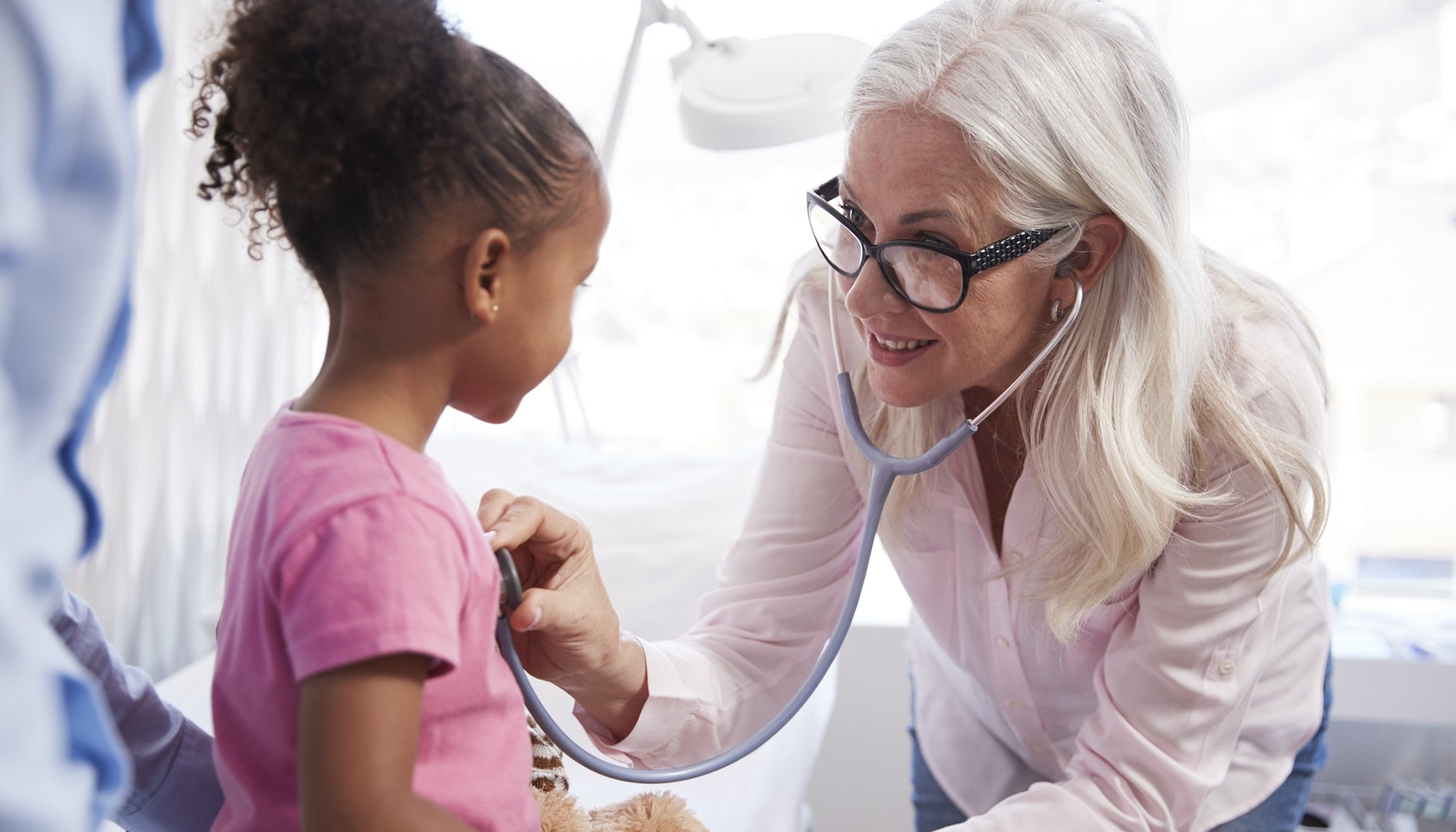 Ärztin untersucht kleines Mädchen mit dem Stethoskop.