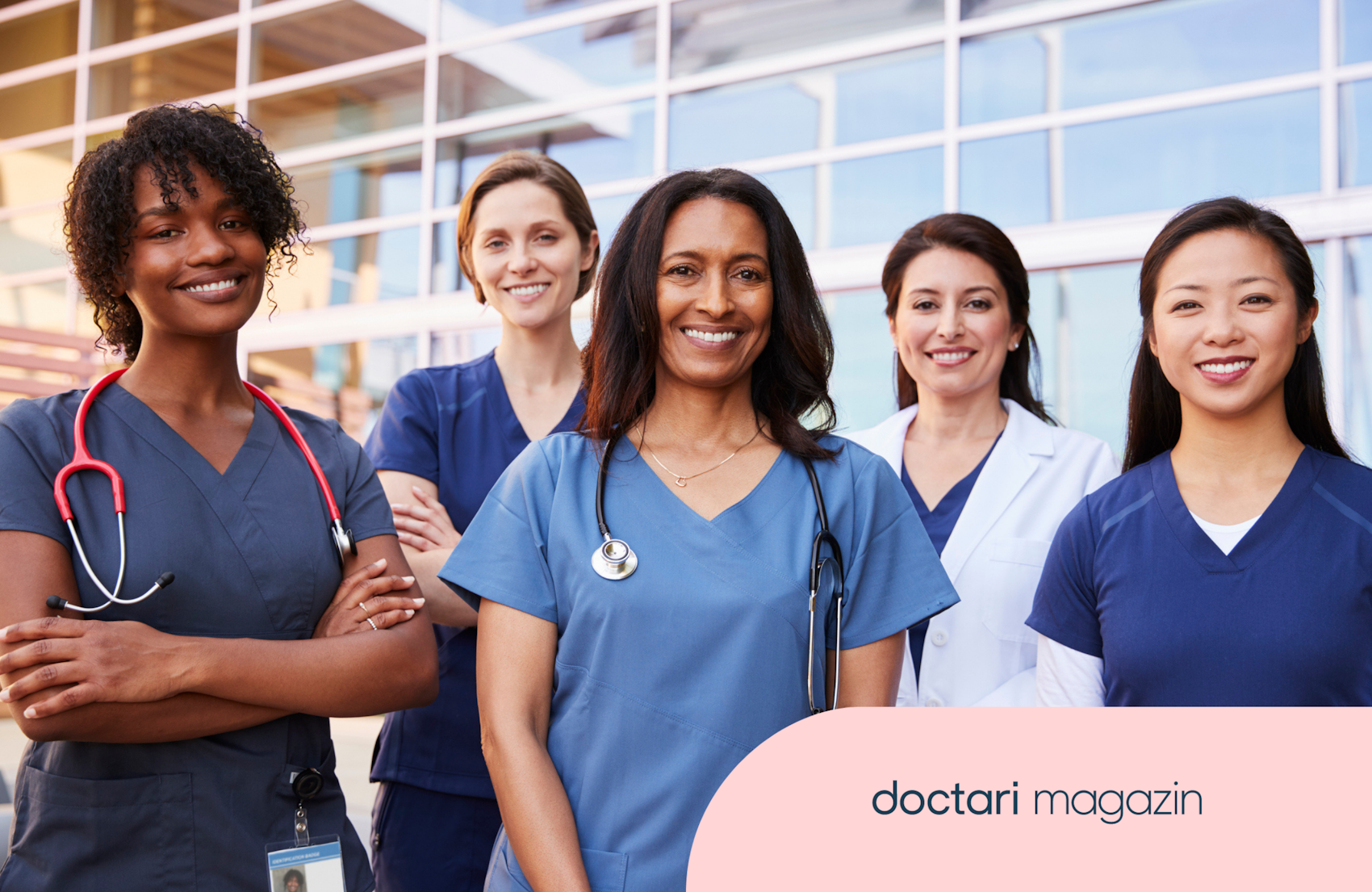 Fünf Frauen in blauen Kitteln und teilweise mit Stethoskop lächeln in die Kamera