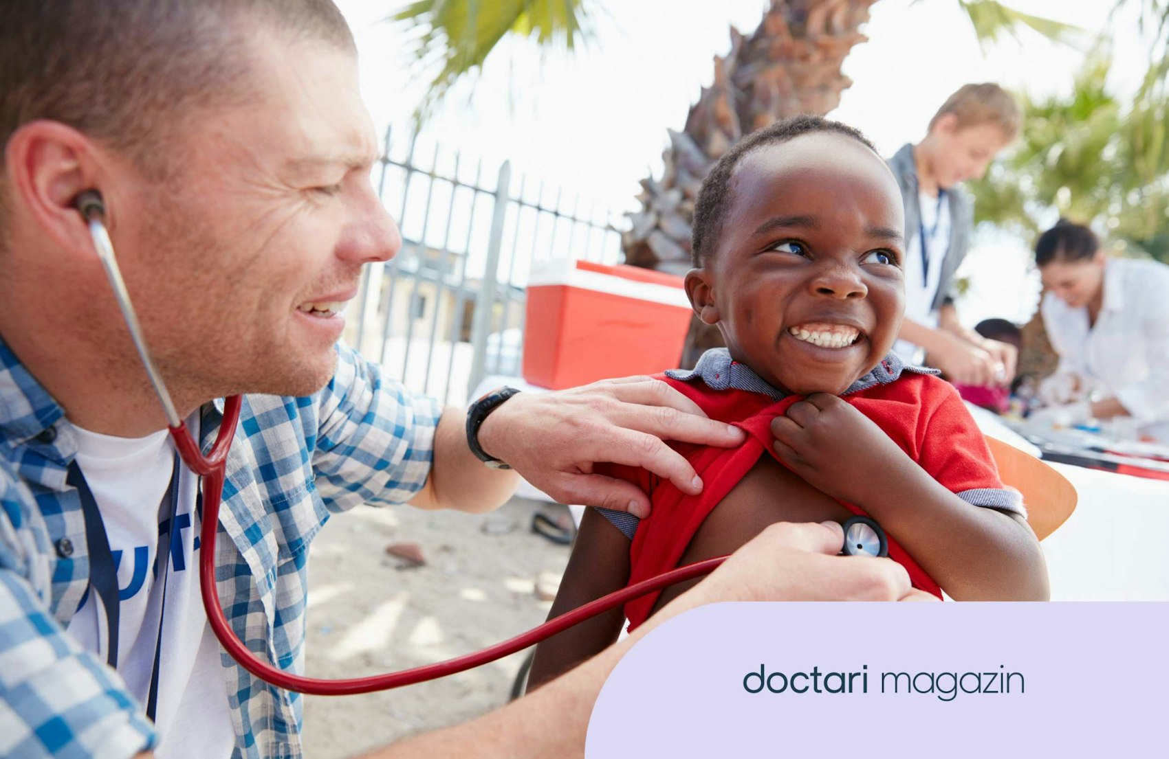 Arzt untersucht lächelnden Jungen mit Stethoskop