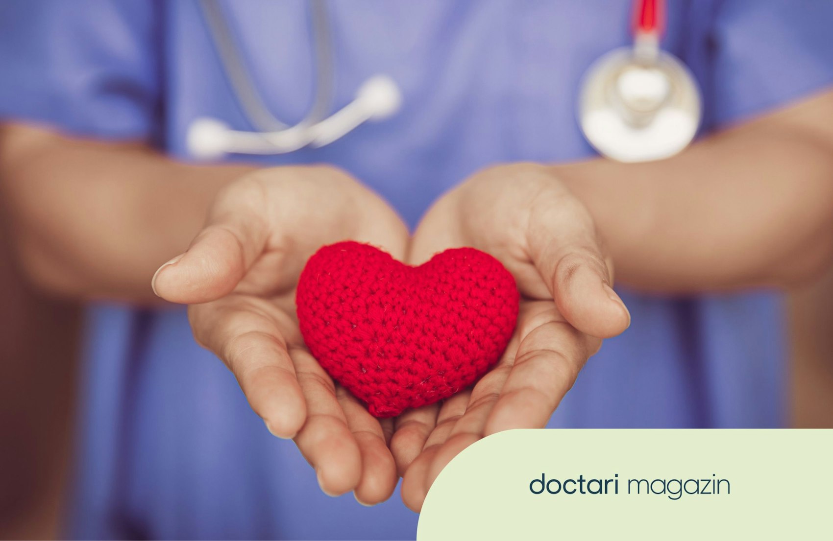 Eine Pflegkraft im Kasak hält ein gehäkeltes Herz in beiden Händen