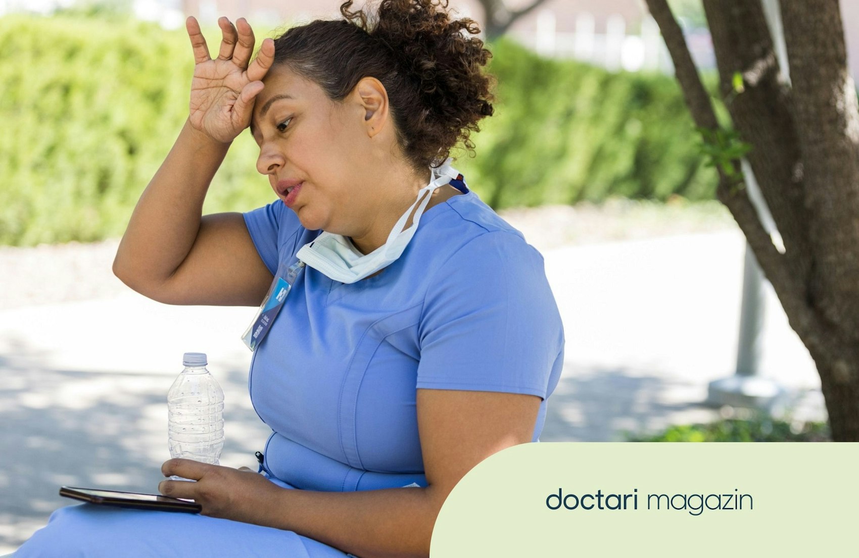Eine Pflegekraft sitzt bei Hitze unter einem Baum und fasst sich an die Stirn.