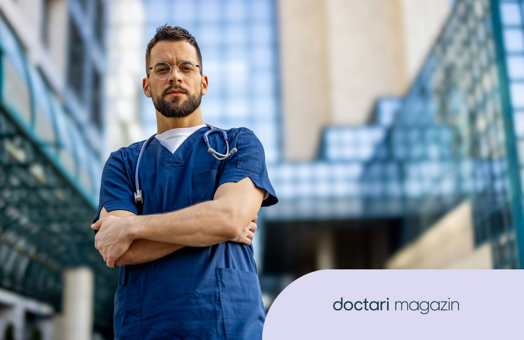 Ein junger Arzt steht vor einem Krankenhaus und blickt ernst in die Kamera