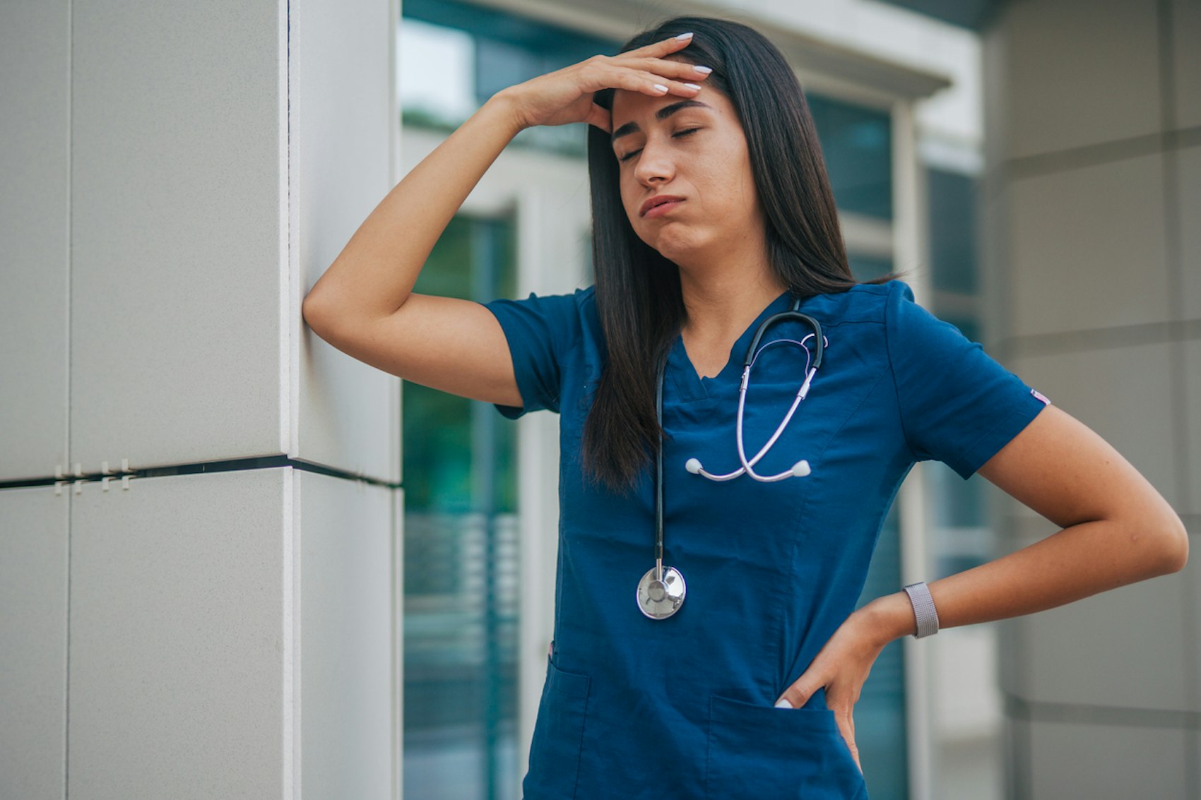 Ausgelaugte Pflegekraft vor dem Krankenhaus