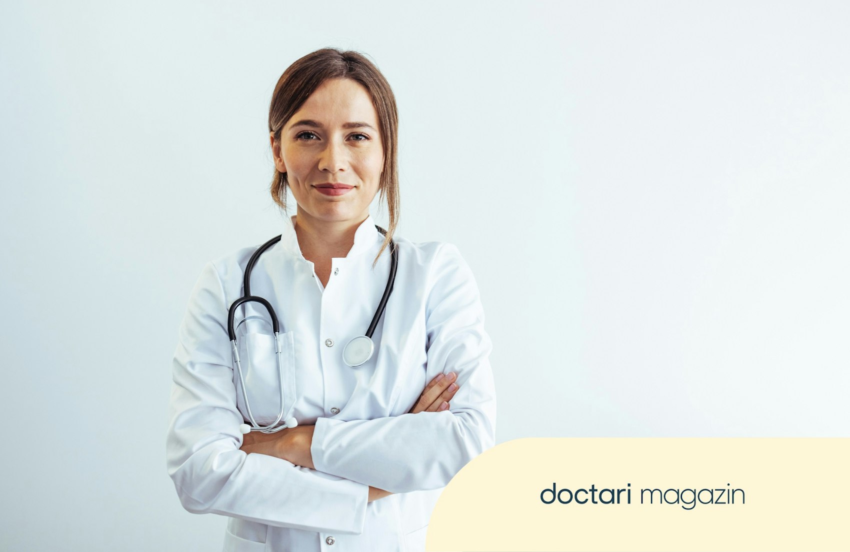 Junge Ärztin im weißen Kittel blickt in die Kamera.