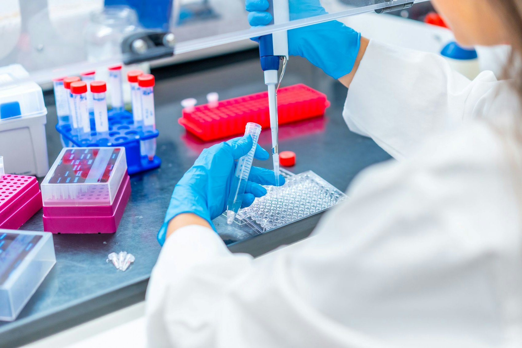 Eine MTLA entnimmt mit einer Pipette Proben in einem Labor