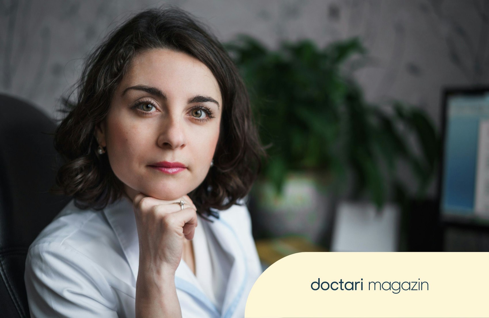 Eine Ärztin sitzt am Schreibtisch und schaut ernst in die Kamera