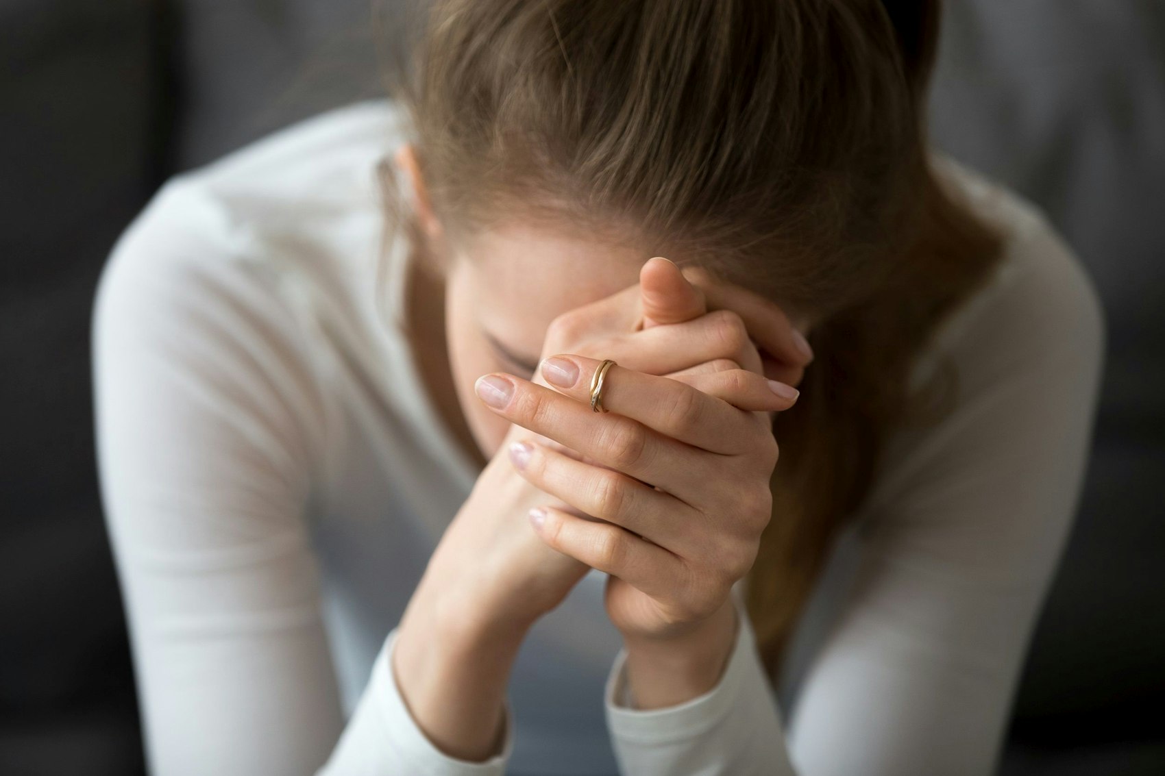 Eine junge Frau legt ihren Kopf in die Hände