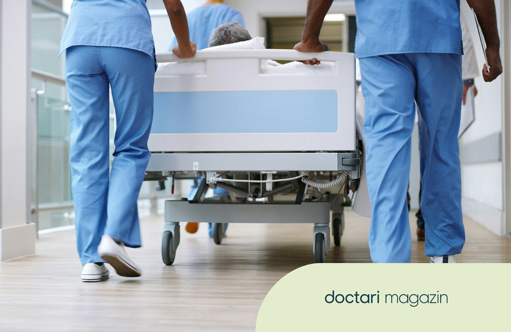 Pflegekräfte schieben ein Krankenhausbett über einen Krankenhausflur.